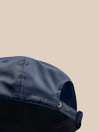 Navy cap close up showing PROTEK branding along the side and curved brim