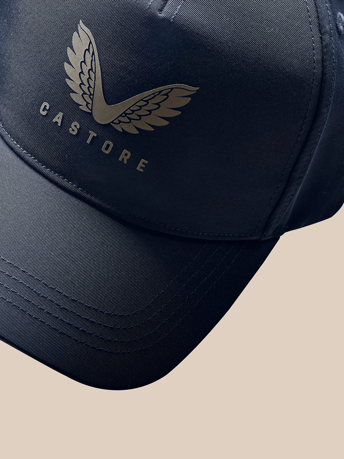 Detail of navy cap side with PROTEK branding and stitching texture