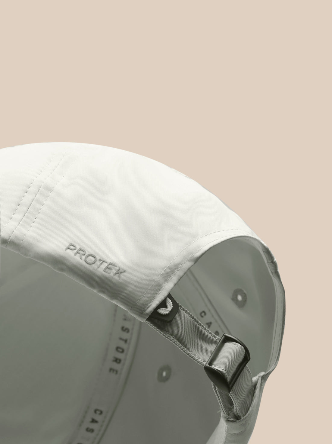 Close-up of the back of a white Active Cap showing an adjustable strap and PROTEK branding.