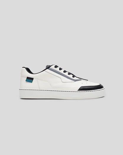 Profile view of white Endstate sneaker with black toe cap and blue striped heel patch.