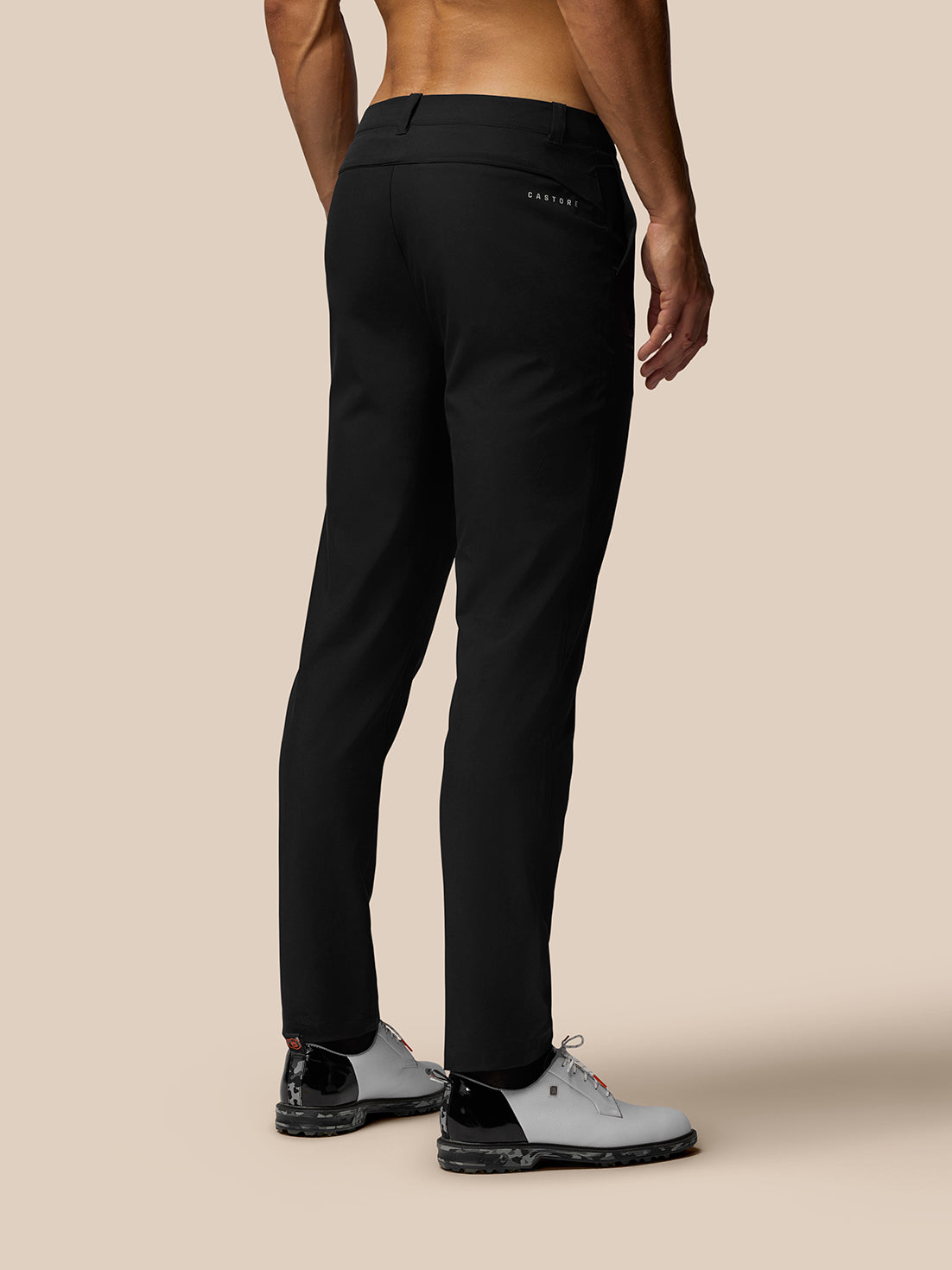 Back view of a man wearing black golf trousers