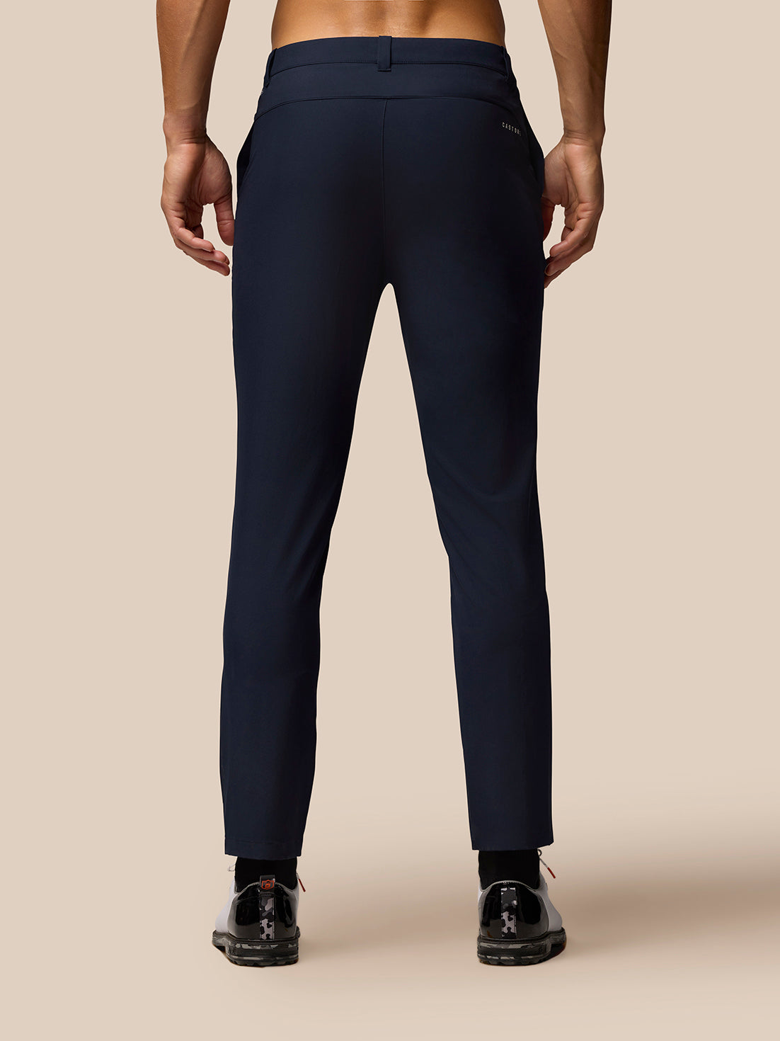 Back view of a man wearing midnight blue golf trousers with a welt back pocket.