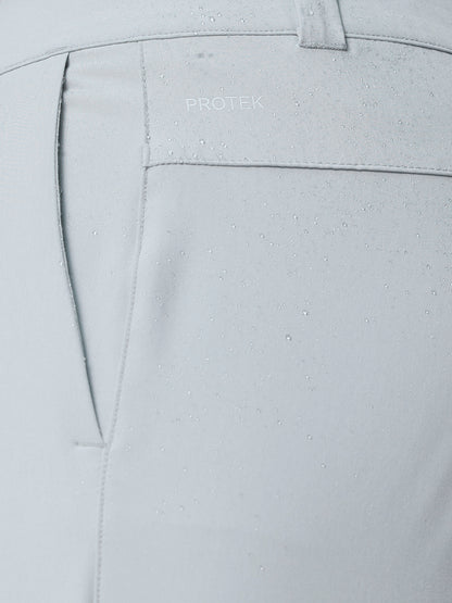 Close up of ProTek water resistant fabric on light grey golf trousers with water droplets.