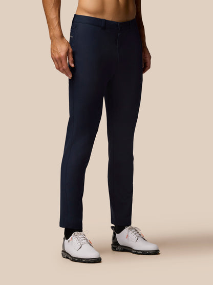 Back view of midnight navy Golf Club Trousers on a model, showing belt loops and neat tapered legs.