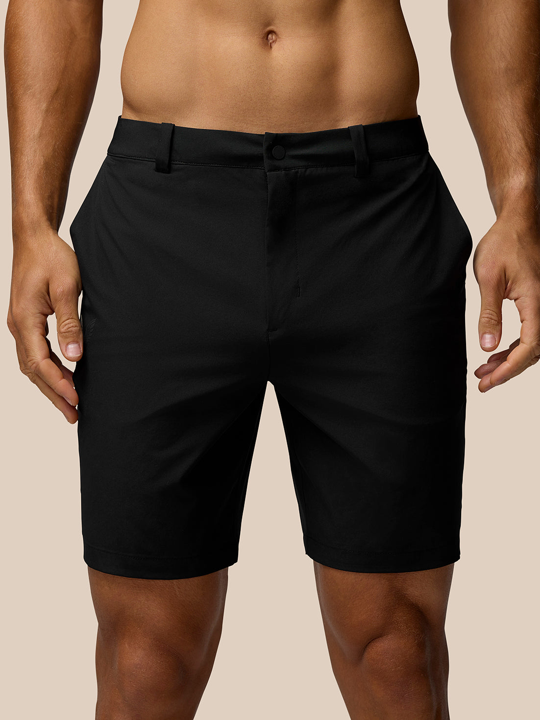 Waist height view of black golf shorts on a model highlighting belt loops and front closure