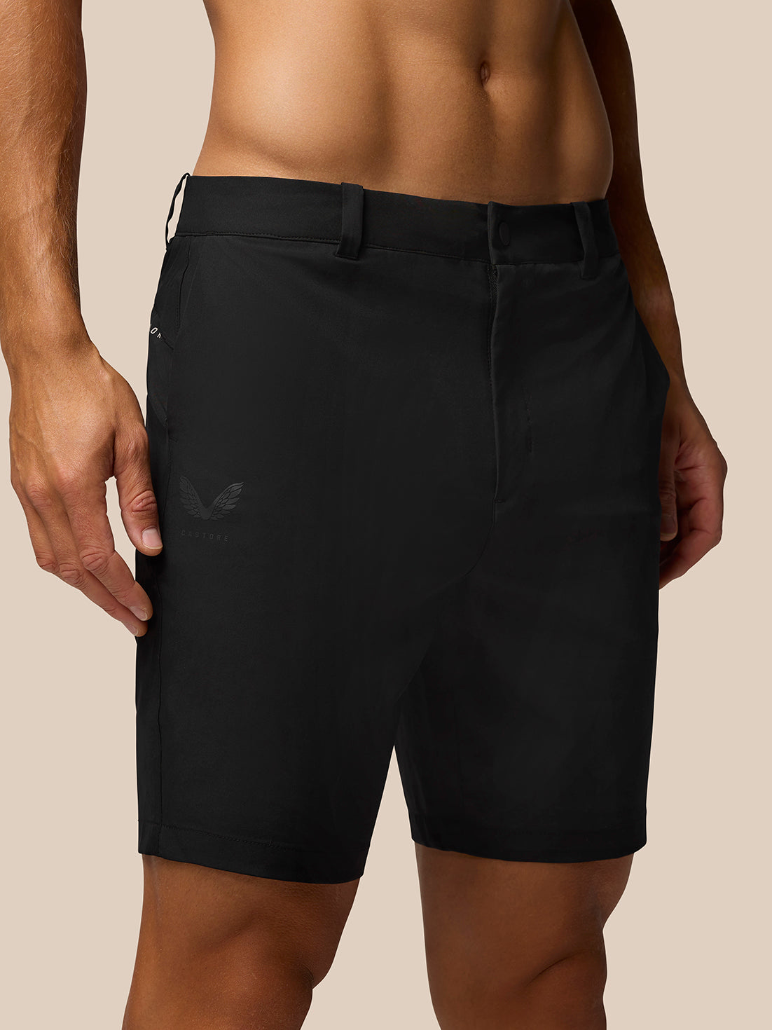 Front view of black golf shorts with belt loops and side pockets, showing Castore branding on thigh