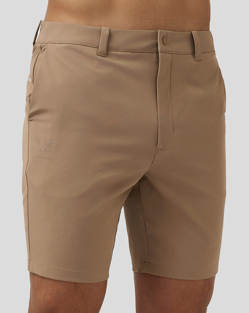 Close up of tan golf shorts waistband with belt loop and back pocket detail.