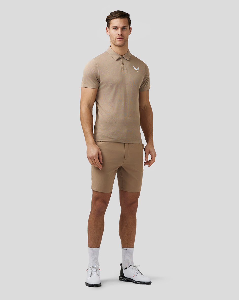 Full body shot of man in clay golf shorts and polo with white socks and golf shoes.