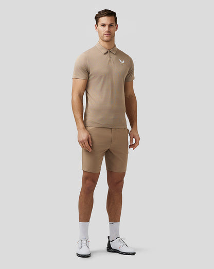 Full body shot of man in clay golf shorts and polo with white socks and golf shoes.