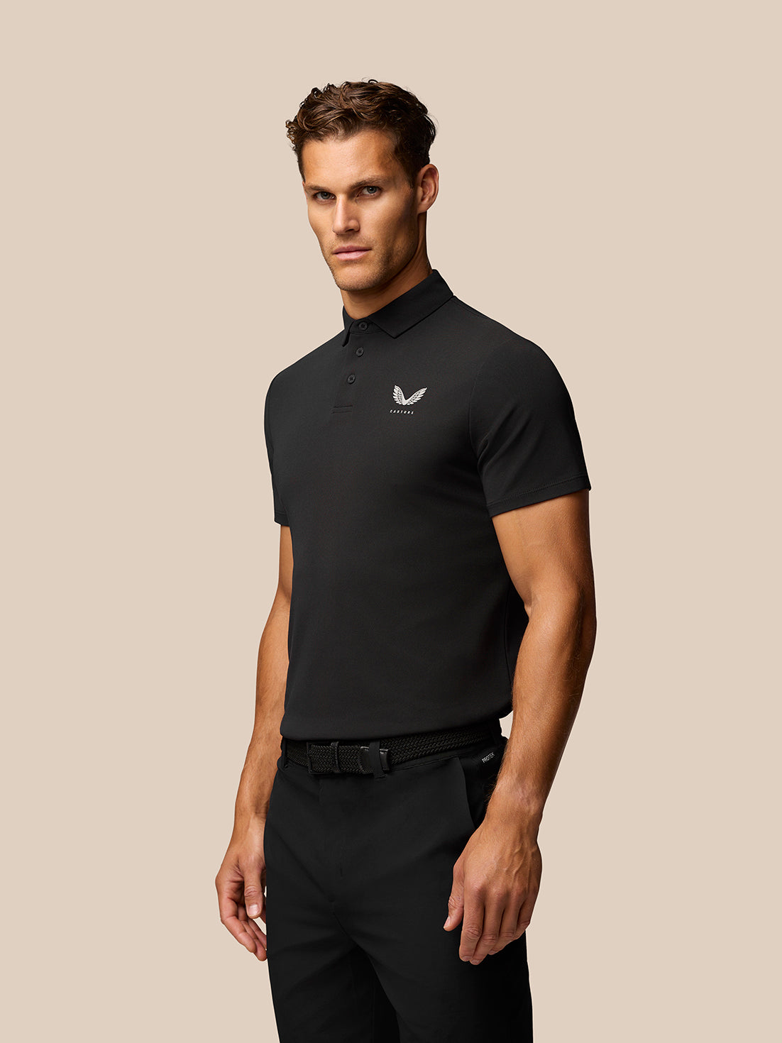 Male model in a black polo with a three-button placket and a small Castore logo on the left chest