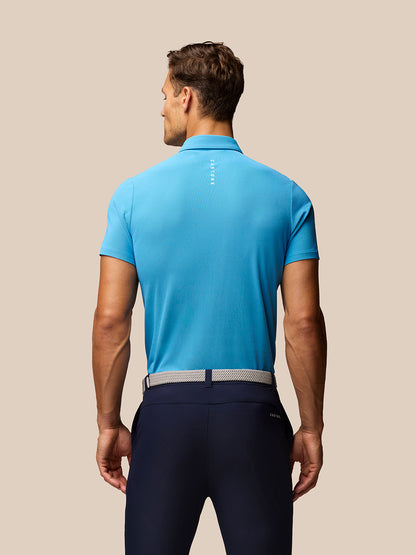 Back view of a model in Corn Blue Club Golf Polo showing subtle Castore branding along the upper back