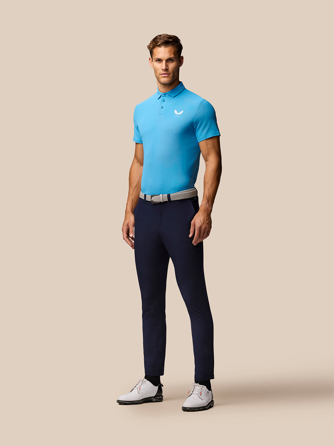 Man wearing corn blue Club Golf Polo with polo collar and three-button placket Castore branding on chest.