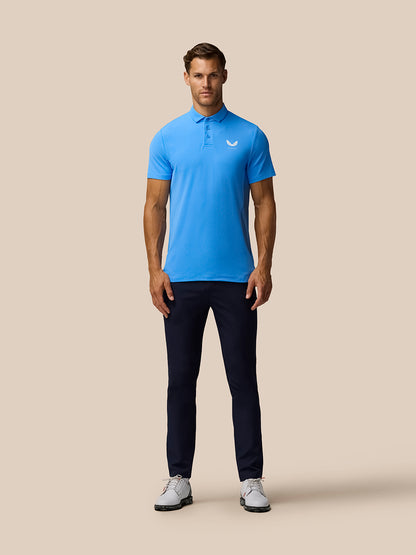 Full-length shot of male model in cool blue Golf Club Essential Polo with navy trousers and belt.