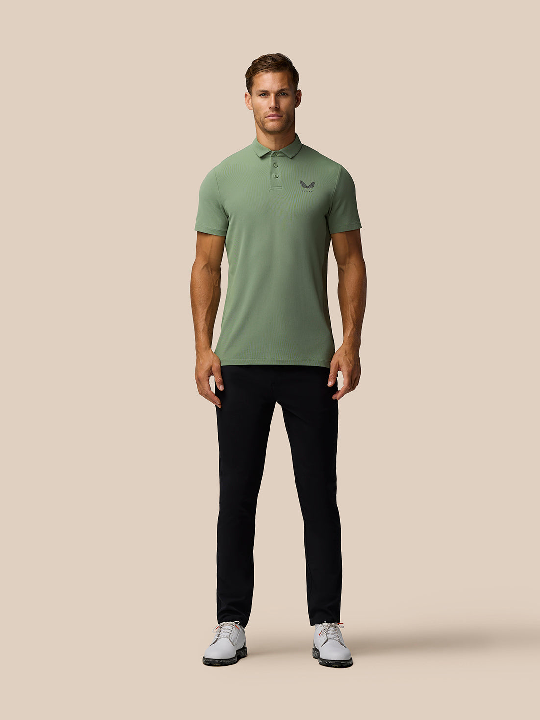 Front view of male model wearing Thyme Golf Club Essential Polo in sage green with Castore logo on left chest