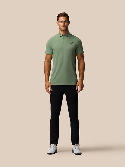 Front view of male model wearing Thyme Golf Club Essential Polo in sage green with Castore logo on left chest