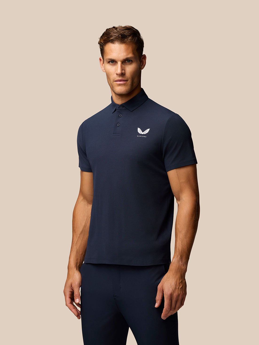 Male model wearing midnight navy Golf Club Essential Polo with Castore logo on chest.