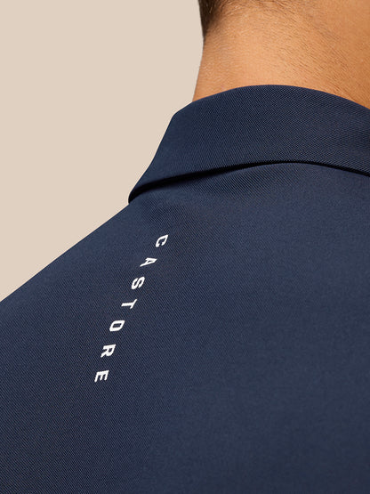 Close up of a navy golf polo collar from behind with Castore branding along the upper back