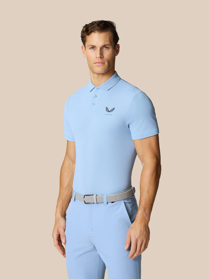 Male model wearing sky blue golf polo with short sleeves, pointed collar and Castore logo on left chest.