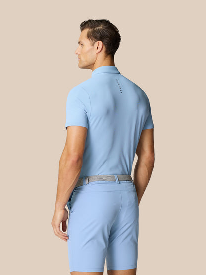 Back view of a man in sky blue Castore golf polo with branding on upper back