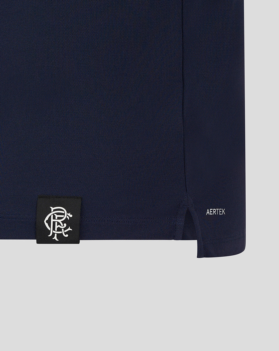 Polo hem close-up with black label patch featuring white crest and AERTEK branding