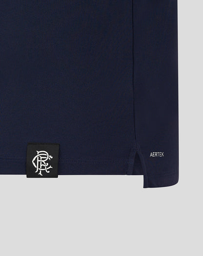 Polo hem close-up with black label patch featuring white crest and AERTEK branding