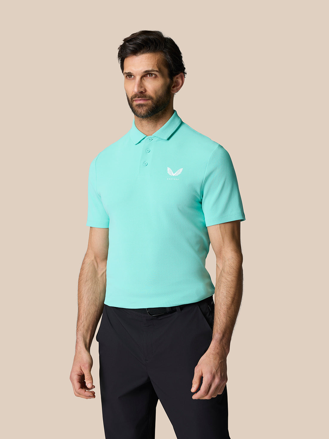 Male model wearing a light aqua Golf Club Essential Polo with a polo collar and chest logo