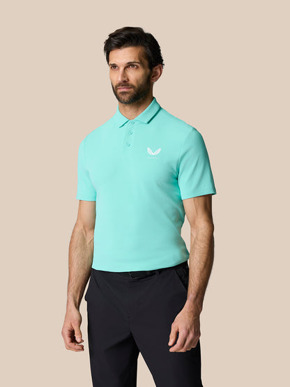 Male model wearing a light aqua Golf Club Essential Polo with a polo collar and chest logo