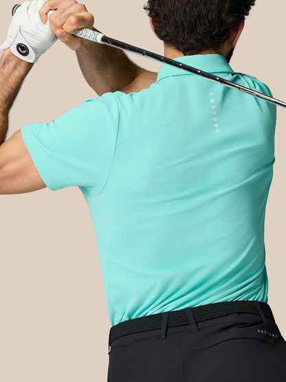 Back view of man in light aqua Golf Club Essential Polo with Castore branding along the back.