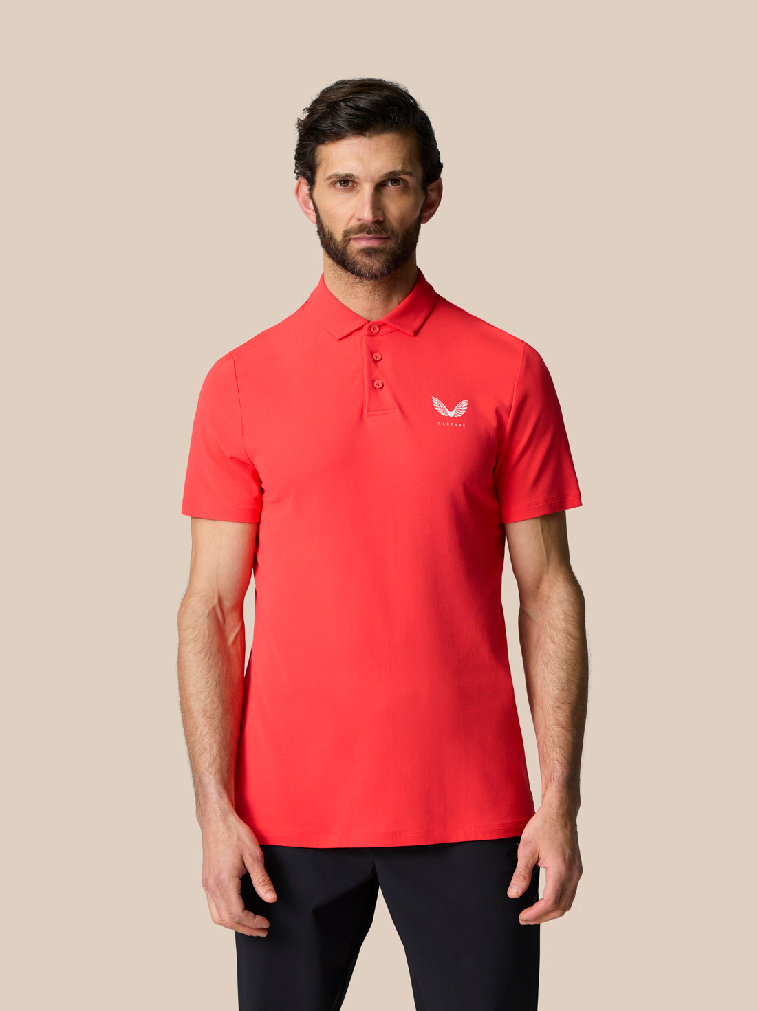 Front view of male model in red Golf Club Essential Polo with a three button placket and Castore logo on chest