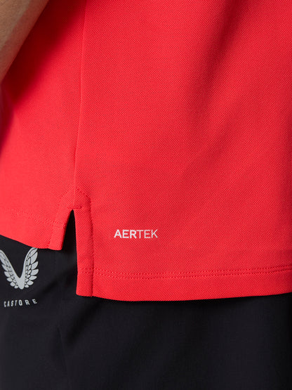 Close up of red golf polo fabric with Aertek branding near the hem