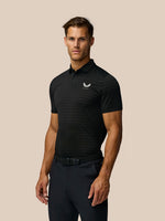 Male model wearing black golf polo with subtle horizontal stripes and Castore logo on chest.