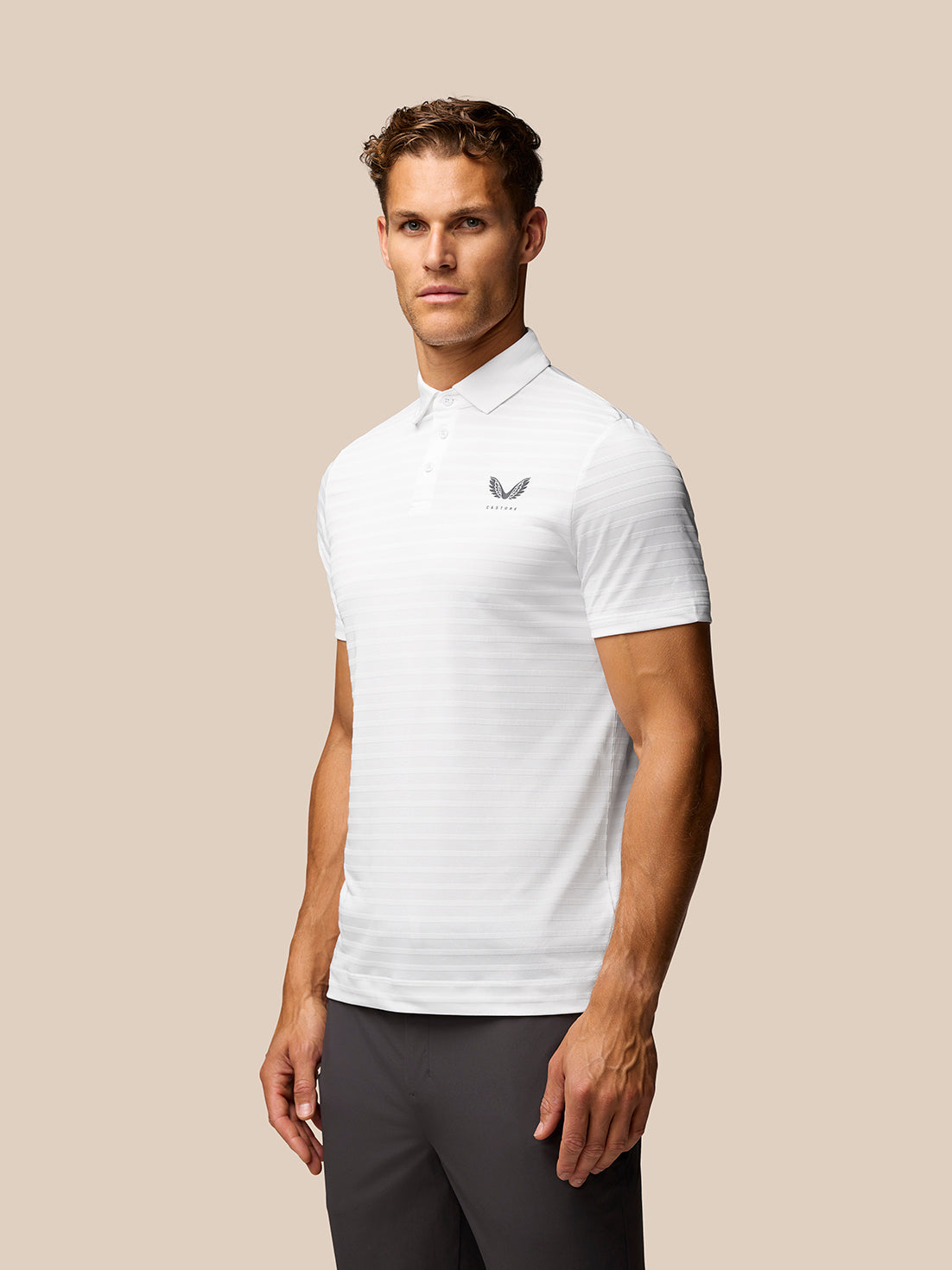 Male model wearing a white textured pique stripe polo with short sleeves and stand collar