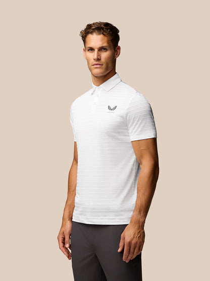 Male model wearing a white textured pique stripe polo with short sleeves and stand collar