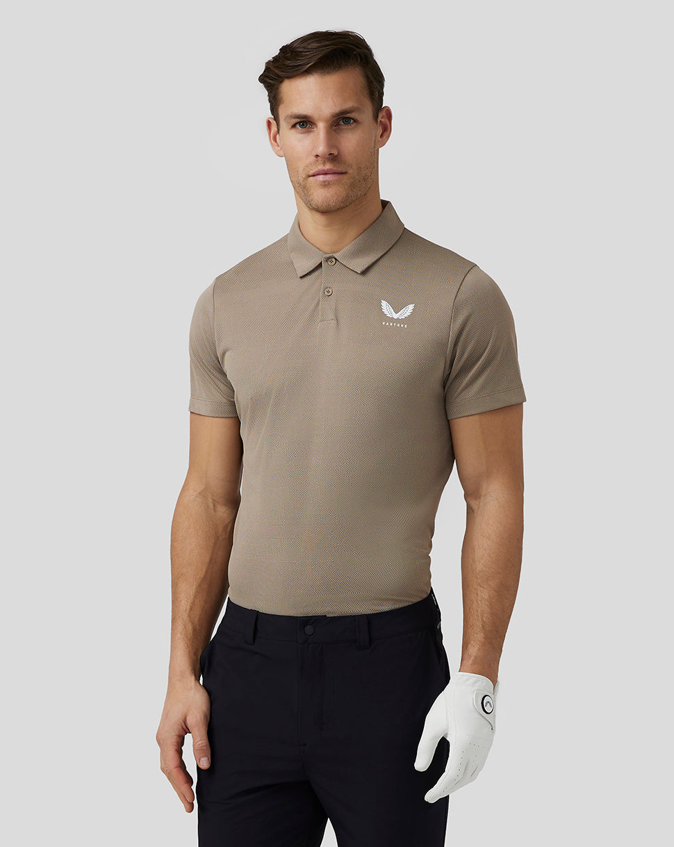 Male model wearing clay Pinnacle Knit Polo with white Castore logo on left chest.