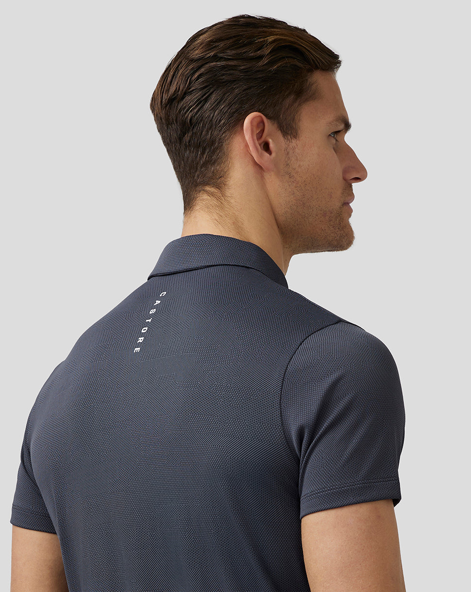 Side profile of a male model in pewter Pinnacle Knit Polo showing textured fabric and Castore branding