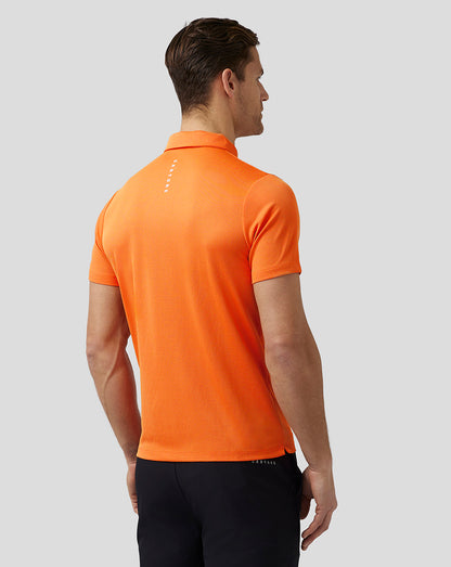 Back view of a man in a bright orange golf polo with Castore branding on the upper back