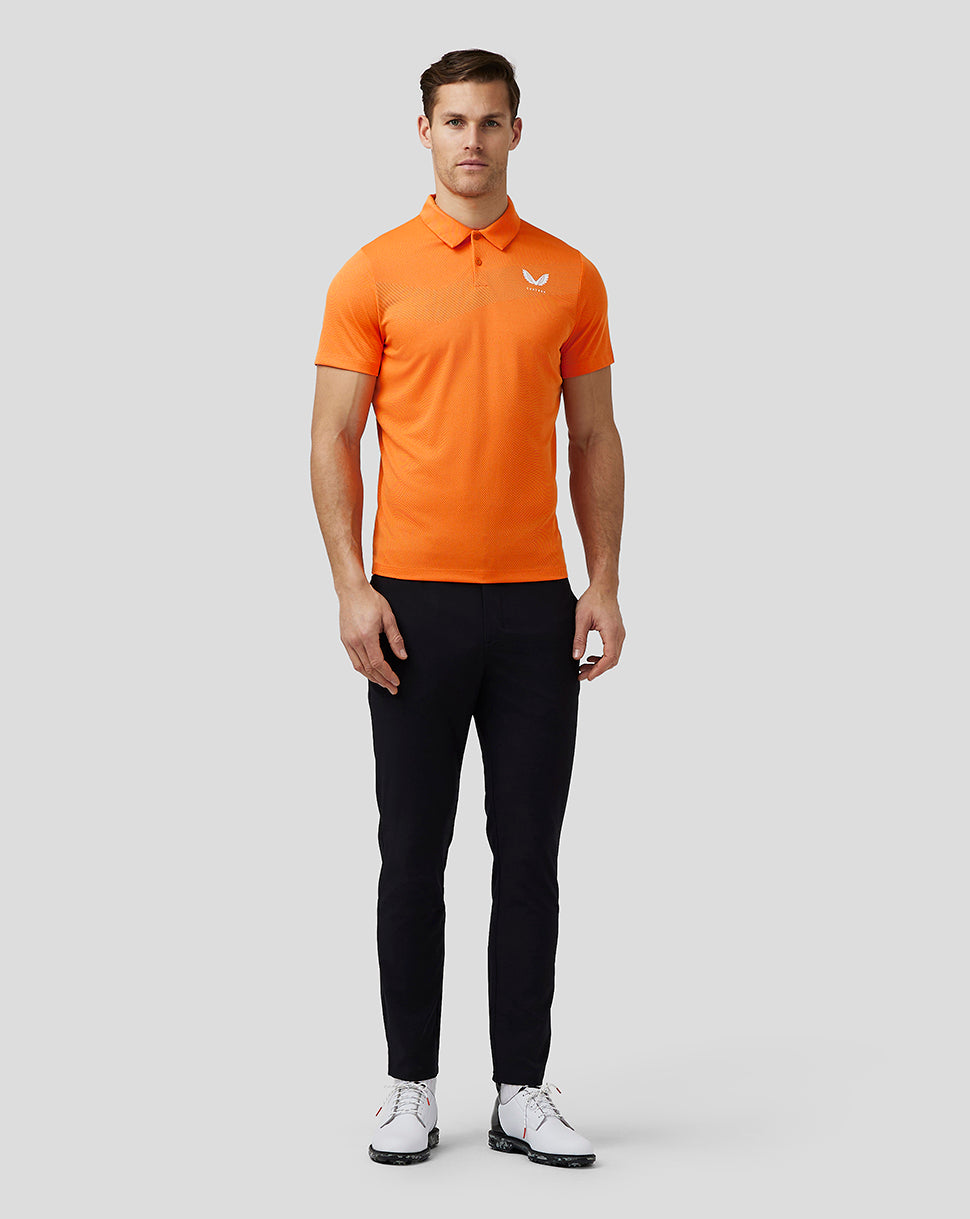 Waist up front view of a man wearing a bright orange golf polo with a three button placket and left chest logo