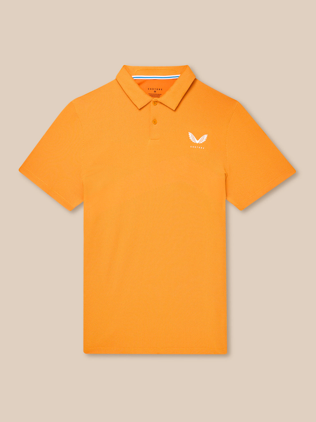Flat lay of orange Golf Pinnacle Polo Mango with collar and chest logo against a beige background.