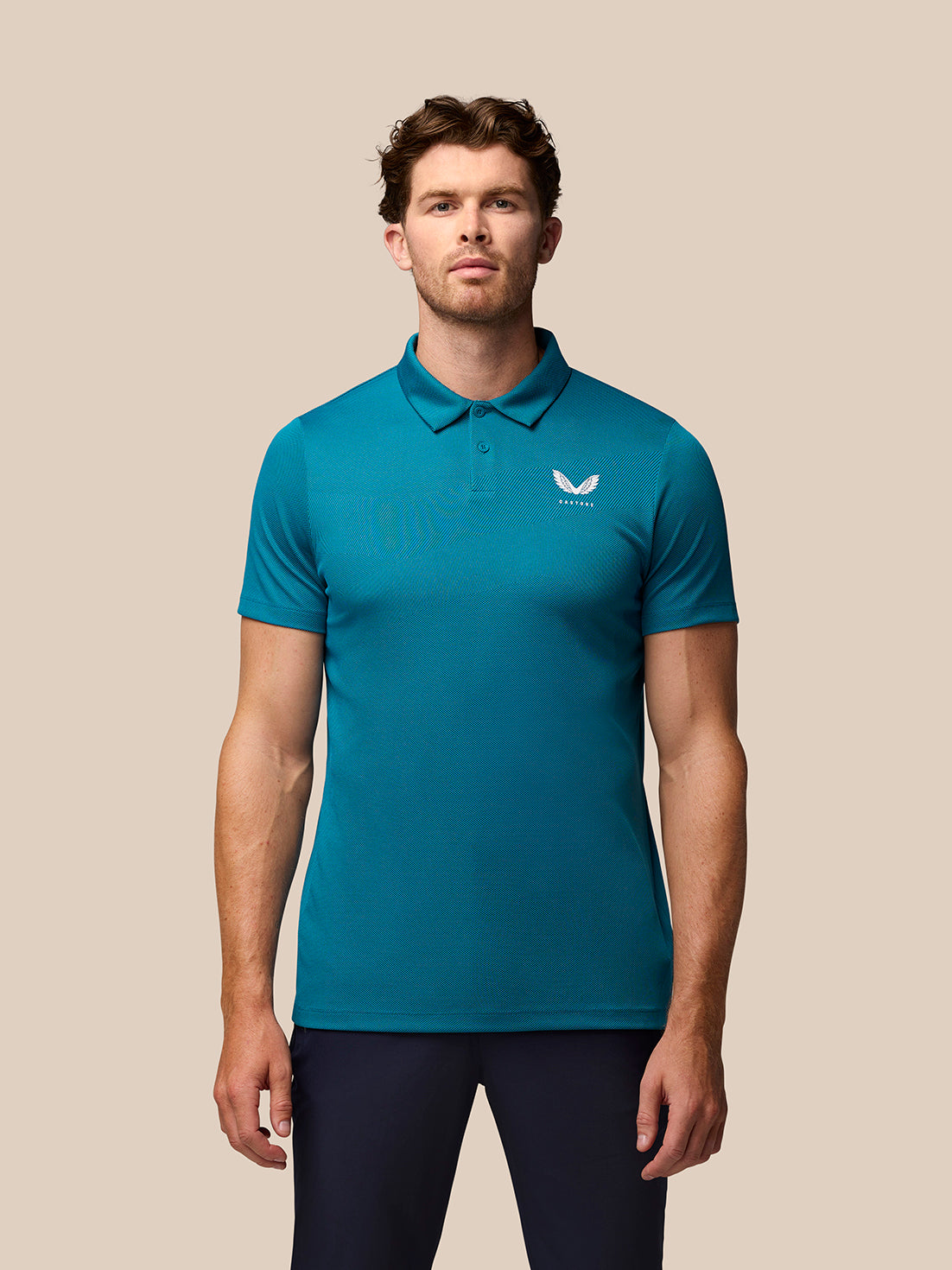 Model wearing dark aqua Pinnacle golf polo with textured knit and Castore branding on chest and back.