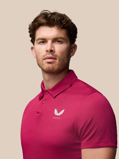 Front view of a man wearing a pink Pinnacle Golf Polo with a pointed collar and Castore logo on the left chest.