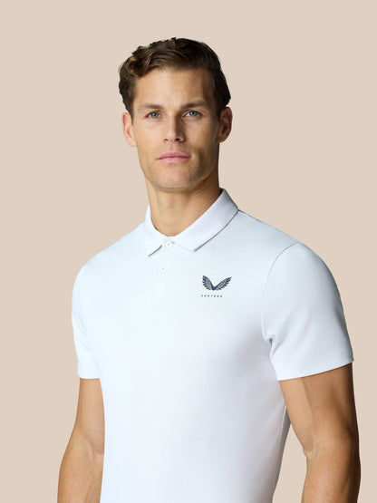 Front view of a male model wearing the white Golf Pinnacle Polo, featuring breathable knit and chest logo