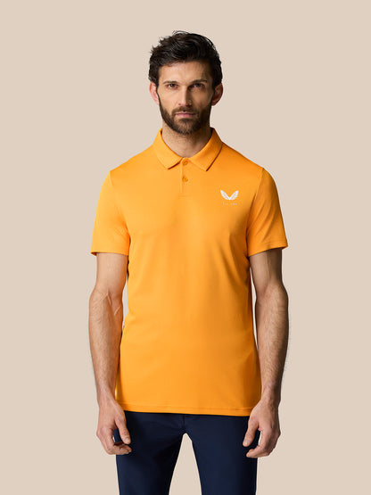Close-up of orange Golf Pinnacle Polo Mango on a male model showing the chest logo.