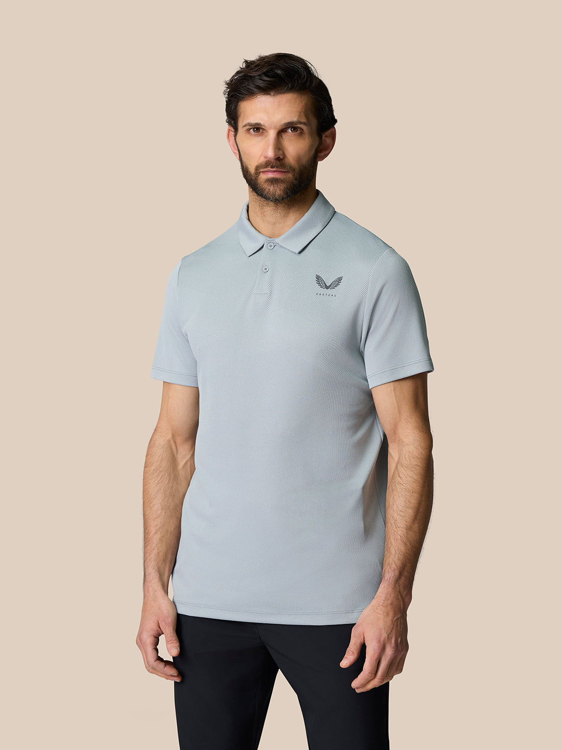 Male model wearing light grey Golf Pinnacle Polo with breathable knit texture and pointed collar.