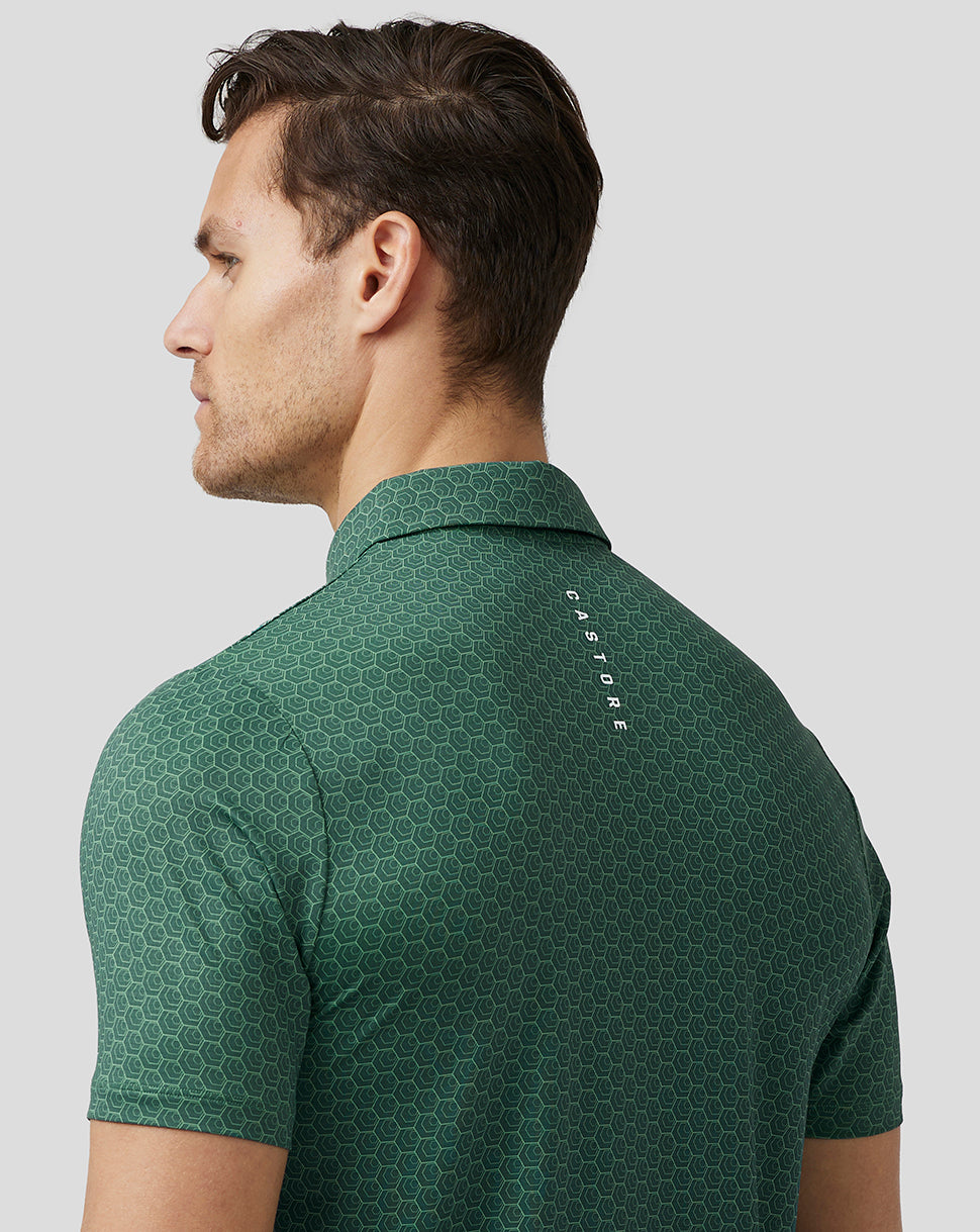 Back view of male in green polo with vertical Castore branding along the upper back