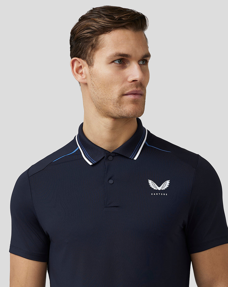 Male model wearing navy Castore Men’s Golf Tech Polo with white striped collar and left chest logo