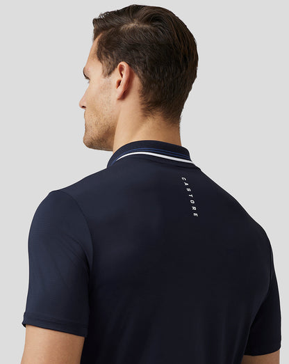 Back view of navy Castore Men’s Golf Tech Polo with striped collar and vertical branding along the upper back