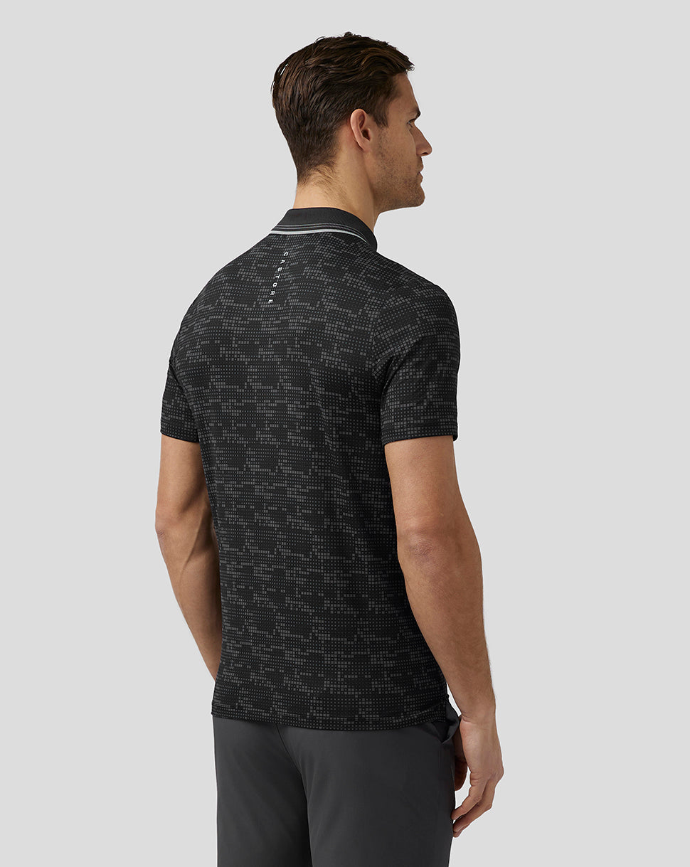 Back view of a man in a black pixel pattern golf polo with Castore branding on the upper back.