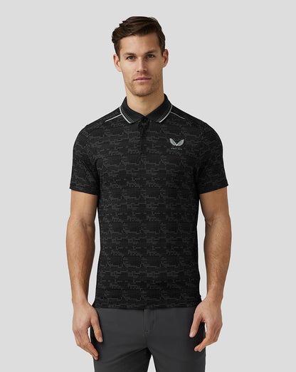 Male model wearing black Printed Tech Polo with geometric pattern and ribbed collar.