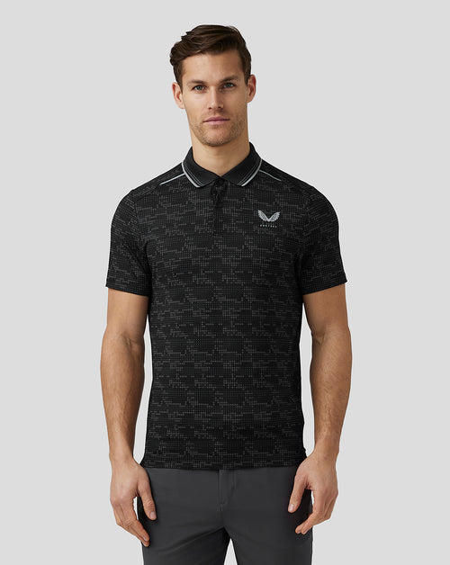 Male model wearing black Printed Tech Polo with geometric pattern and ribbed collar.