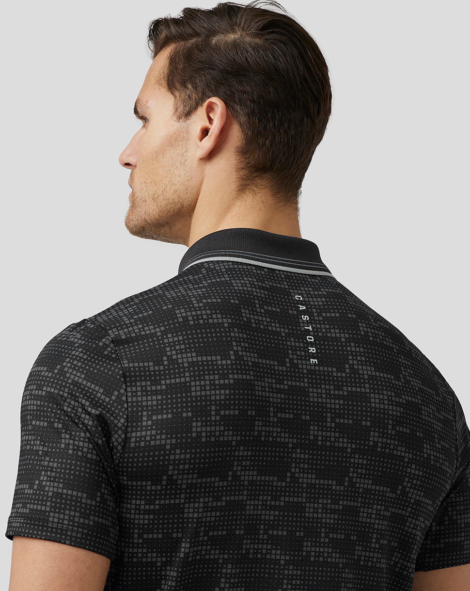 Back view of a man wearing the same black printed golf polo with Castore branding along the upper back